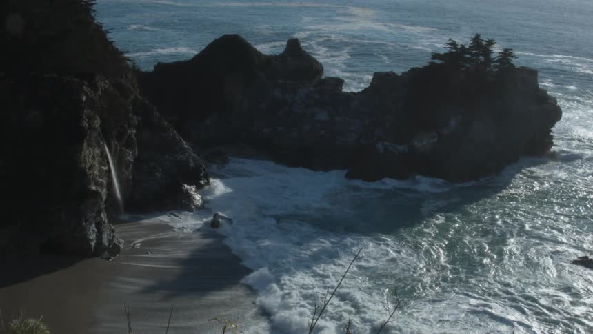 Ocean waves splash up onto the beach on a sunny day