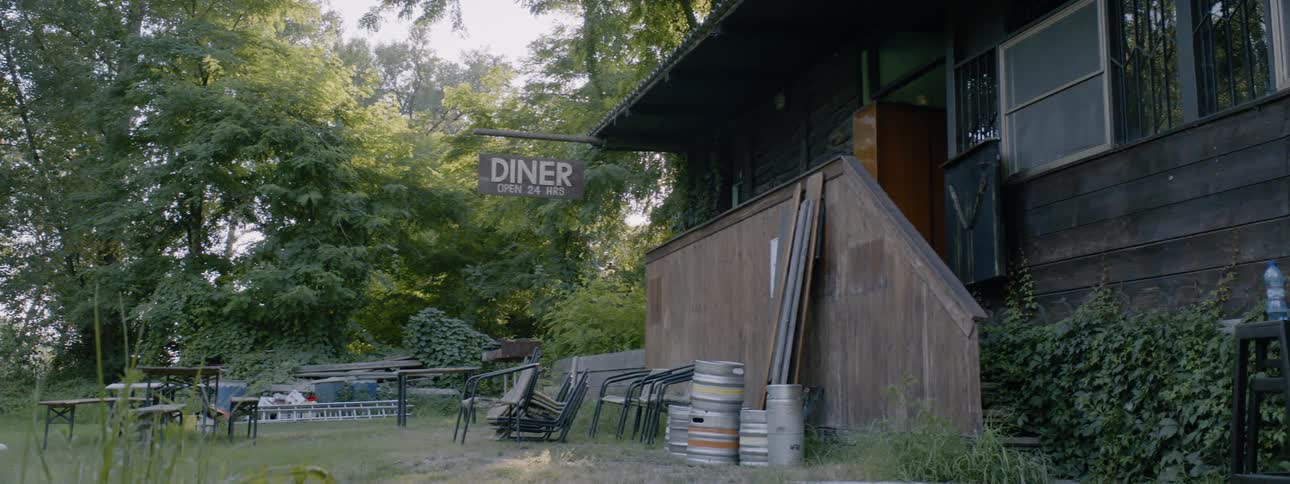 Chairs are stacked outside next to a rural diner