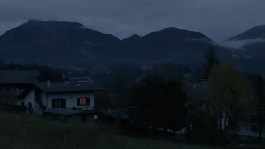 The sun has set by the house near the mountain