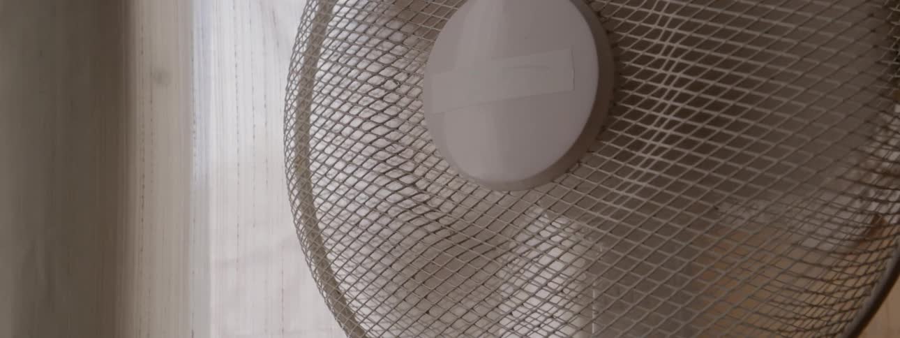 A fan is operating in a room during the day