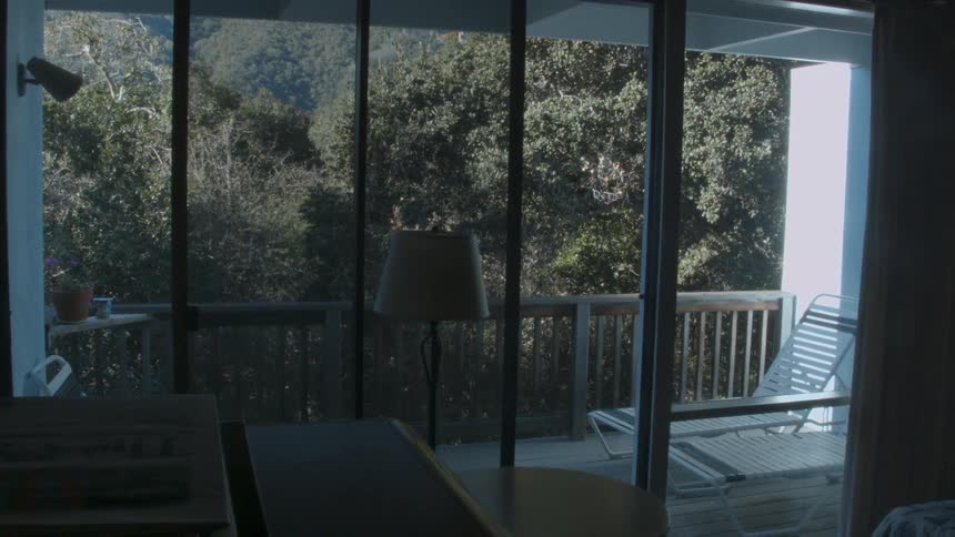 Lounge chairs sit on a bedroom balcony