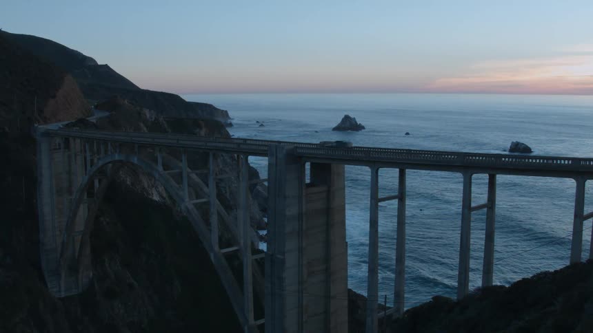 Vehicles travel over a bridge on the coast
