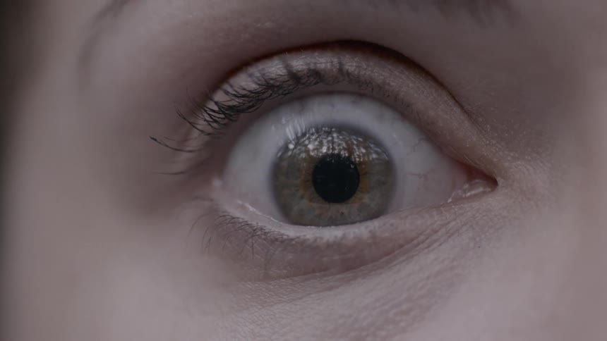 Person's eye opens wide and stares