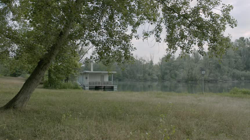 A rural house sits next to a river