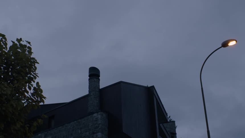 A street lamp glows next to a building