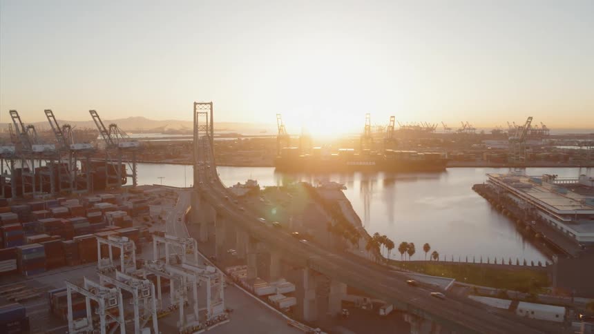 Vehicles travel on a bridge by the docks