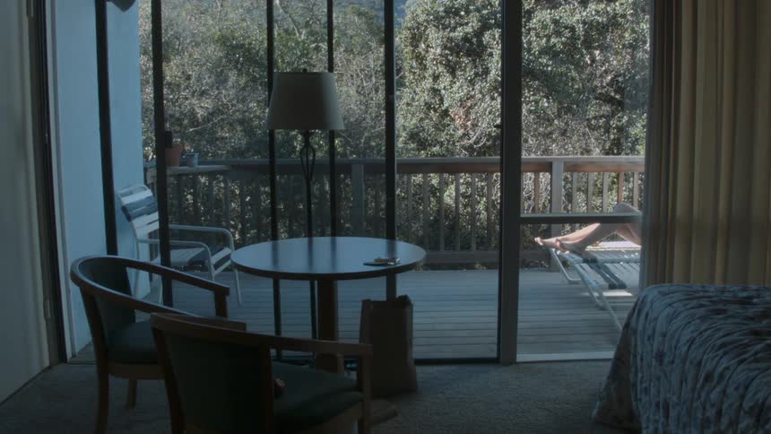 A woman sunbathes on a balcony