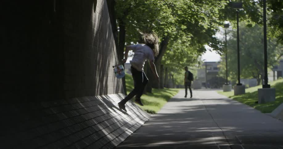 Man skateboard up a wall falls off