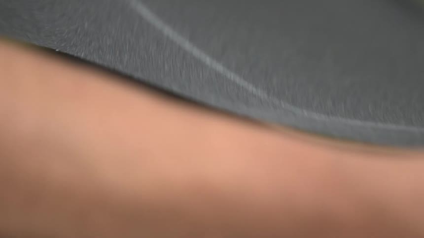 Person is using a small blade to cut around a skateboard
