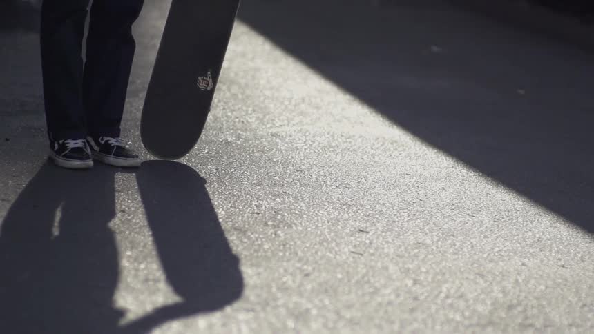 Person twirling their skateboard on pavement