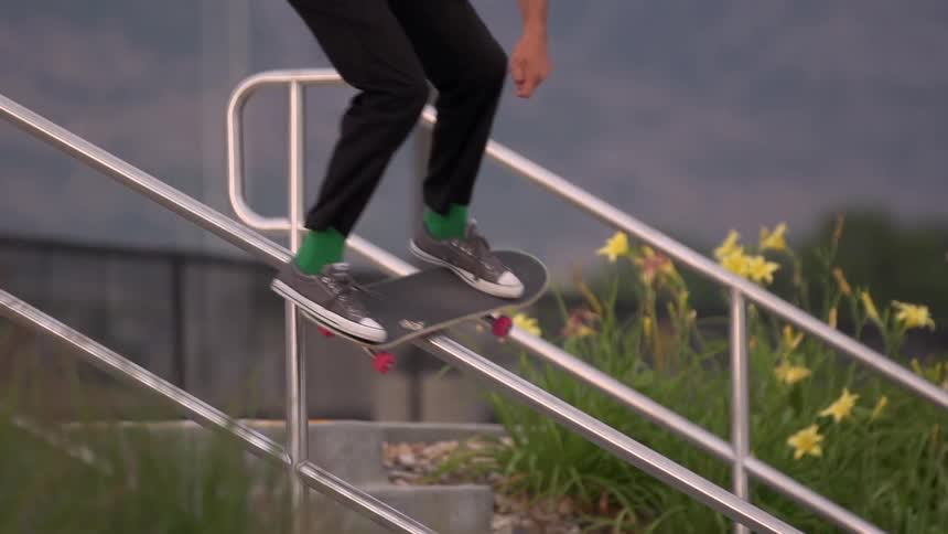 Man skateboards down a rail of steps