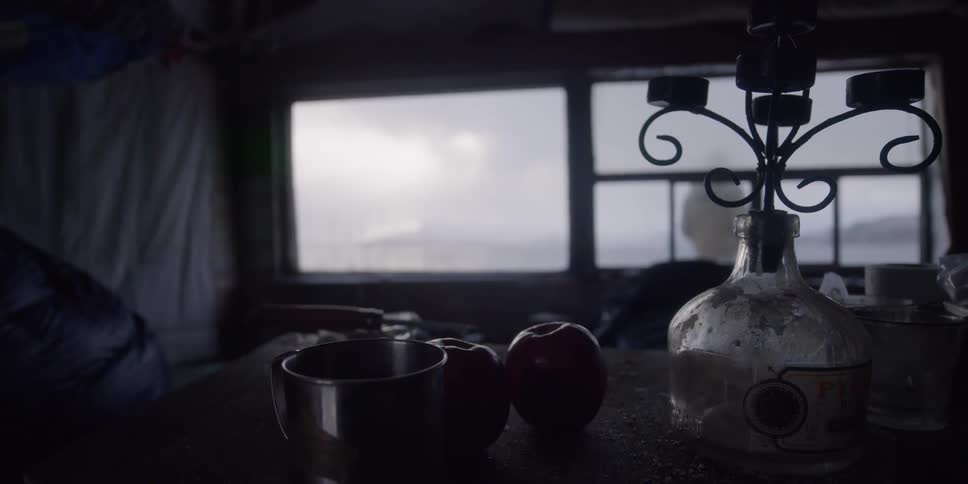 A man walks outside a cabin in the cold
