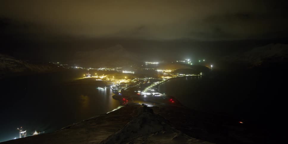 Clouds float over lights in a port