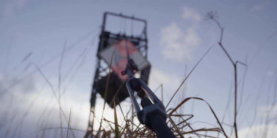 A structure is secured to the ground by a cable