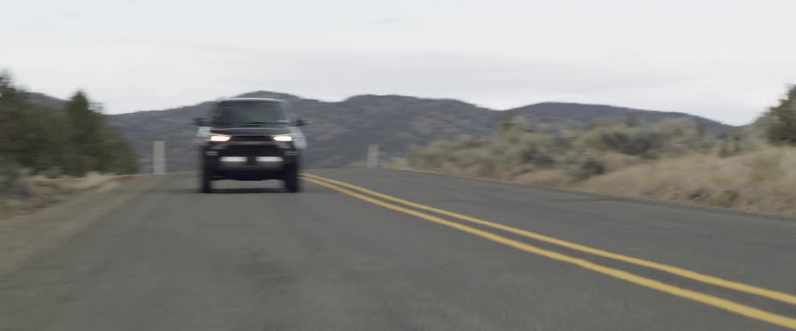 The vehicle passes the fence on the roadside