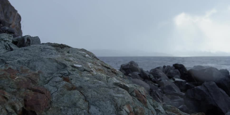 The shore is lined with tall jagged rocks