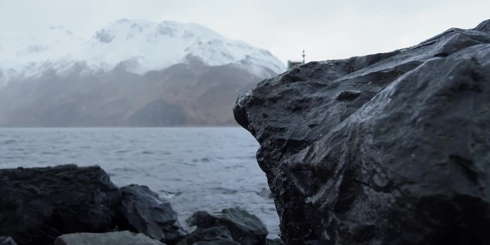 Snow falls near the ocean