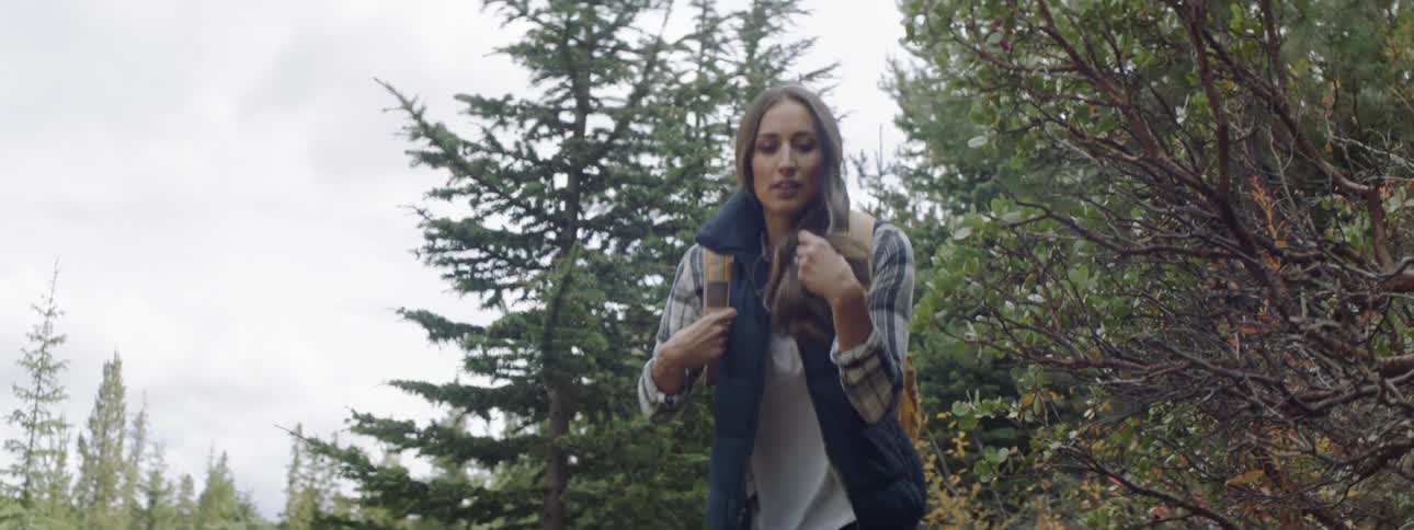 A woman hikes through the woods