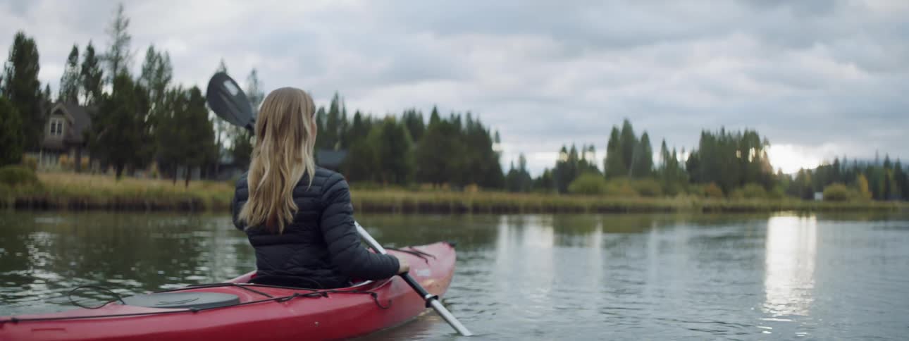 A woman looks back as she rows her boat