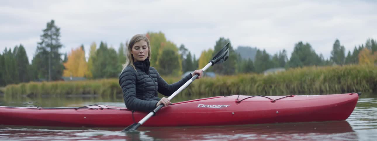 Woman kayaks on a rural river