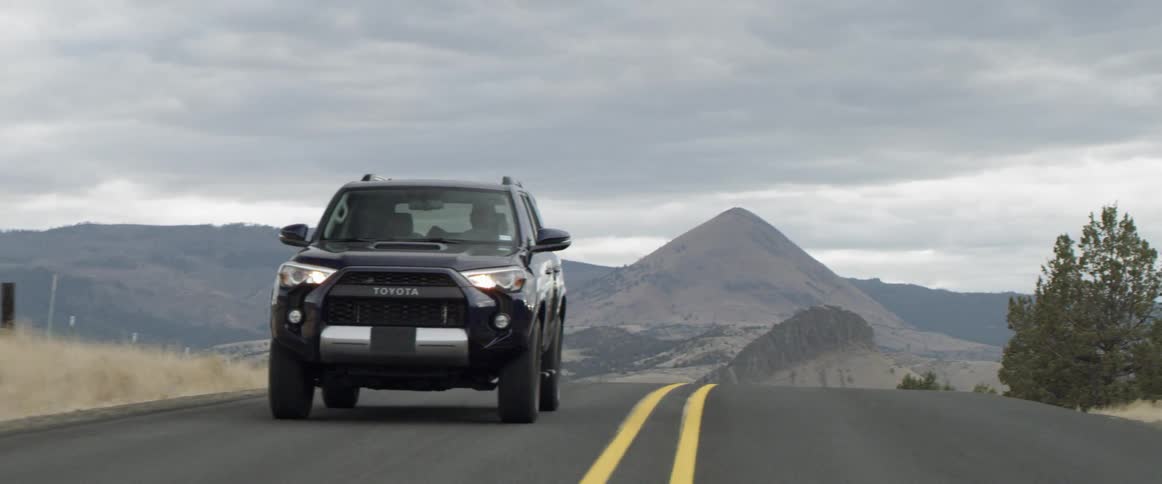 A vehicle drives on a rural road