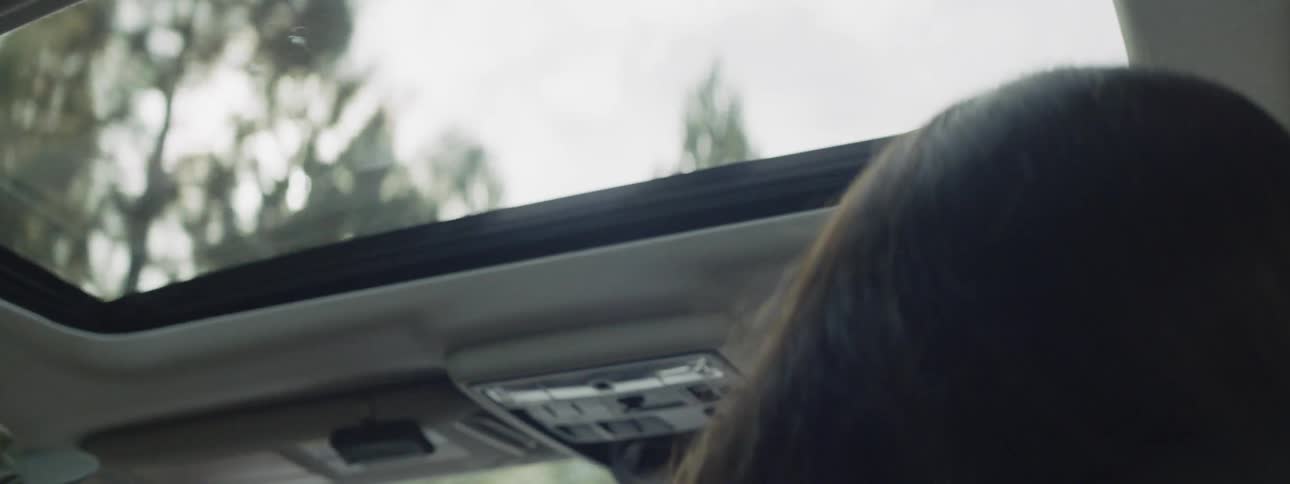 The sun shines in the moving car through the sunroof