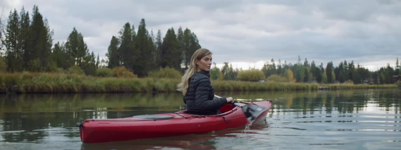 Woman kayaks on a rural river
