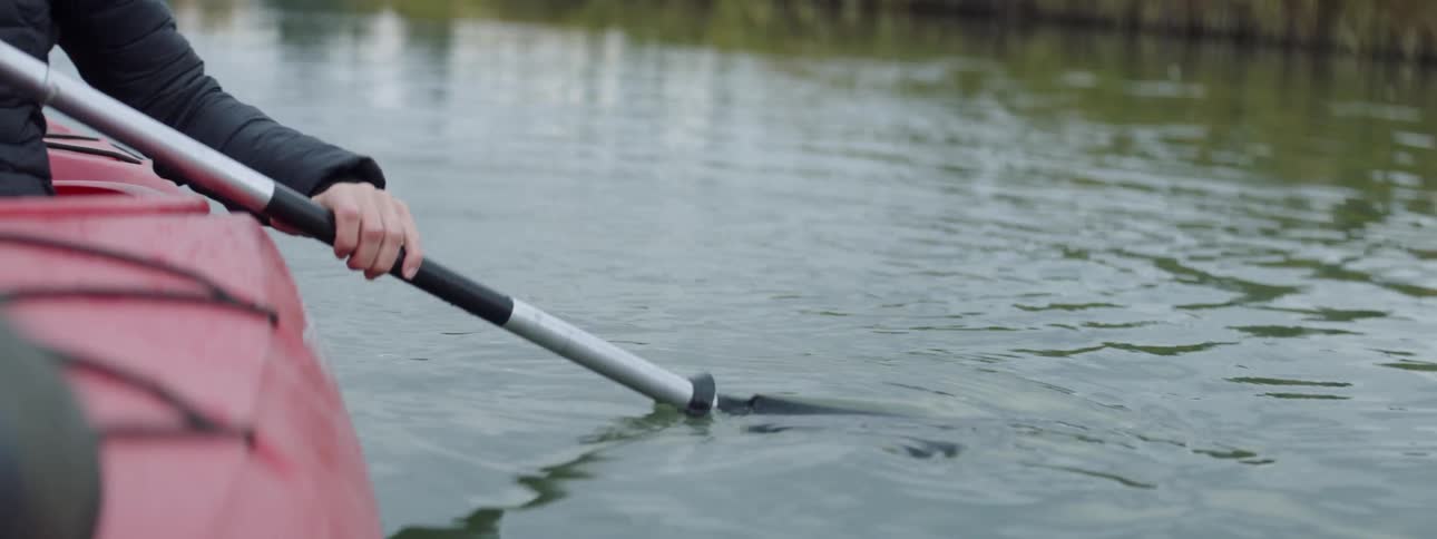 A paddle is entering the water to propel a kayak