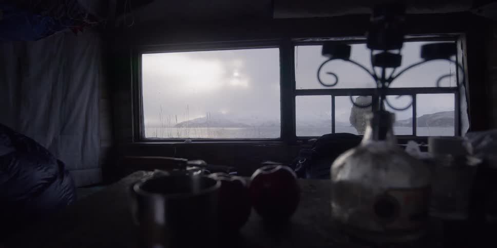 Interior of seaside cabin as man walks outside