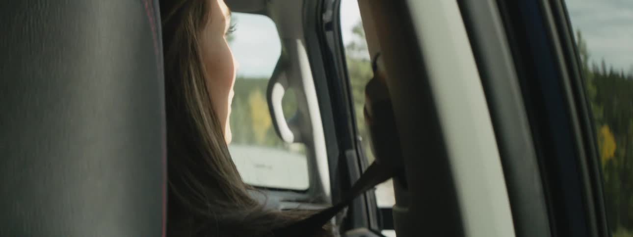 A woman looks out the passenger window of a vehicle