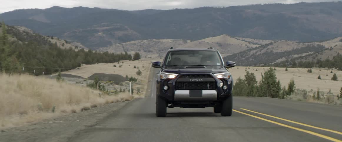 A vehicle drives on a rural road