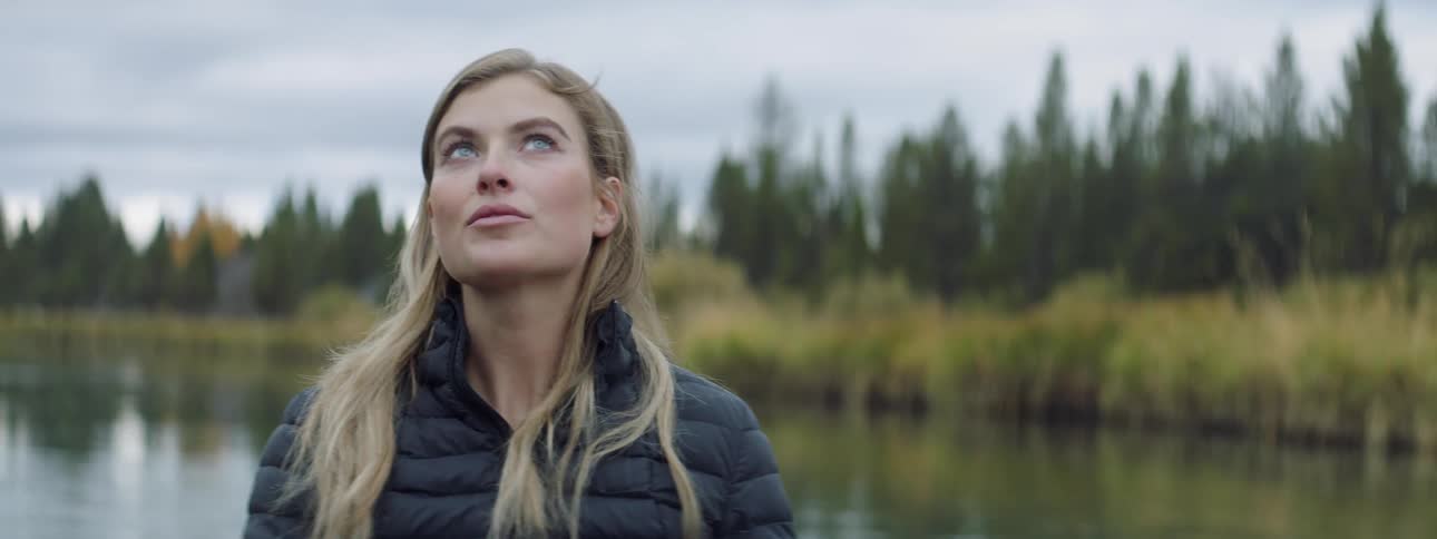 A woman looks around outside in nature