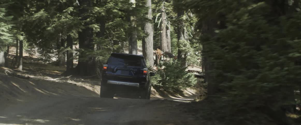 A vehicle drives on a mountain road