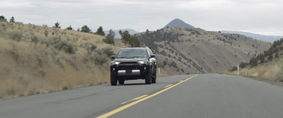 A vehicle drives on a rural road