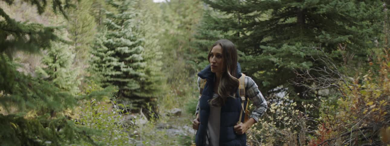 A woman walks through the woods