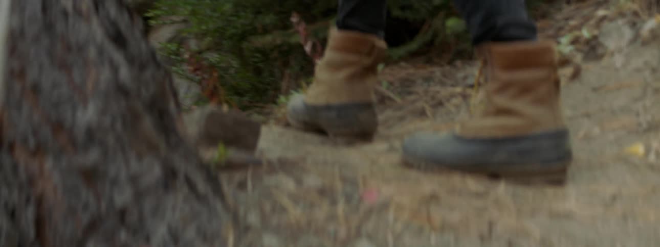 A hiker walks over rocks and dirt