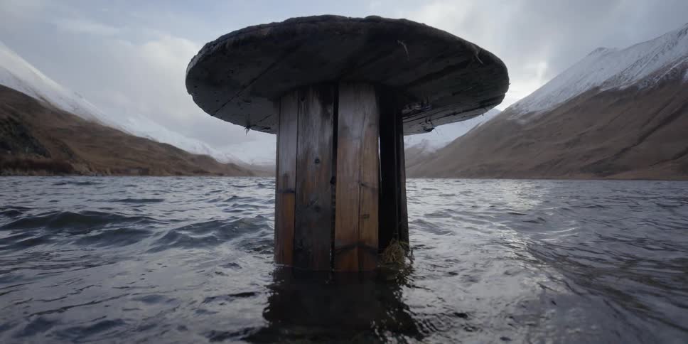Water is lapping around a wooden platform on a winter day