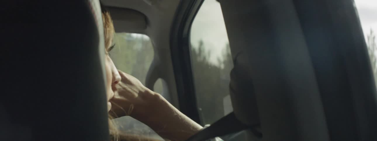 Woman looks outside of a vehicle window