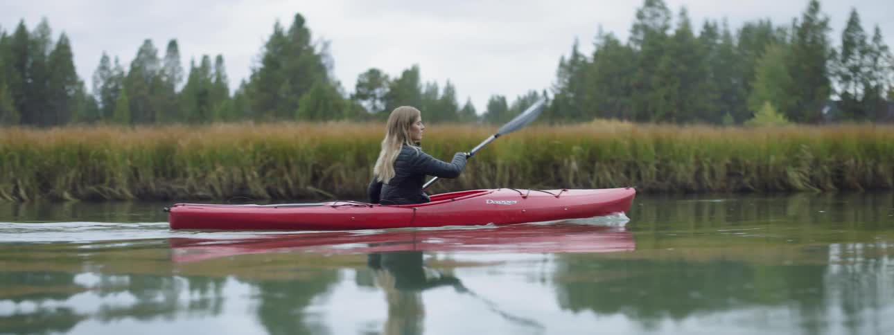Woman kayaks on a river