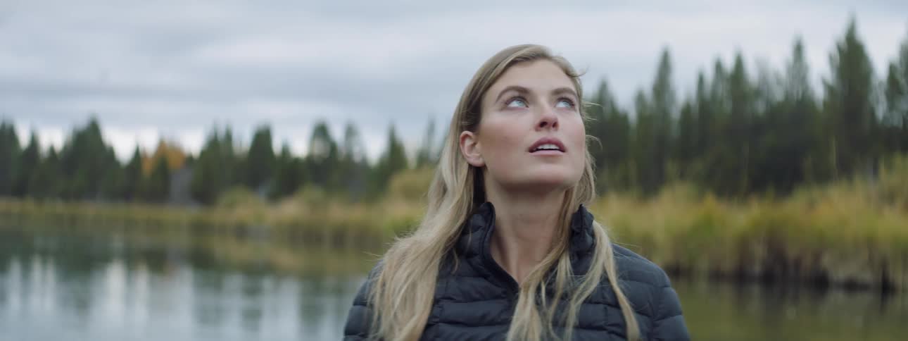 A woman looks around outside in nature
