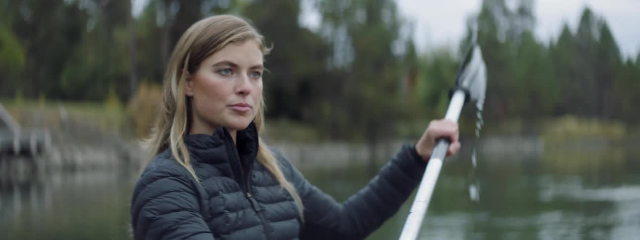 A woman paddles a boat on the water