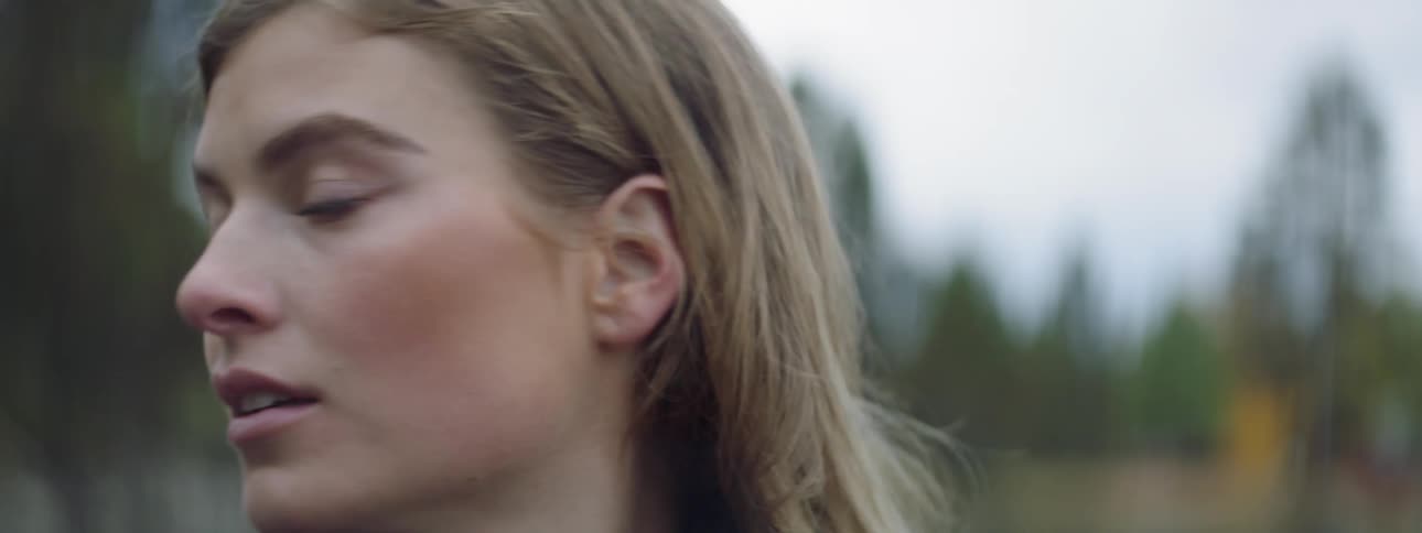 A woman smiles and looks around outside