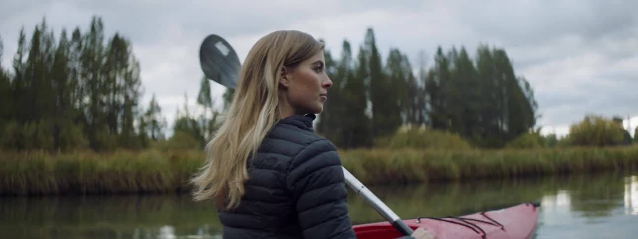 A woman is rowing a canoe