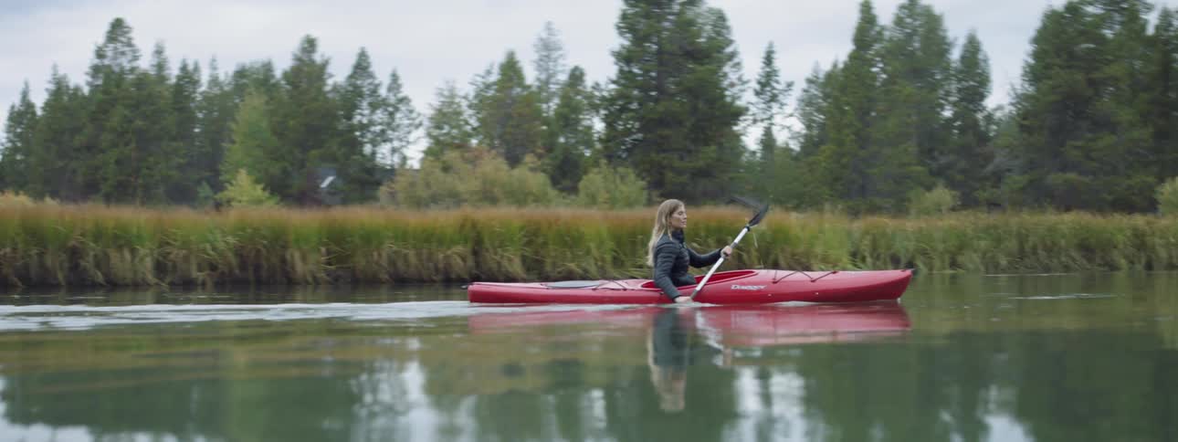 Woman kayaks on a river