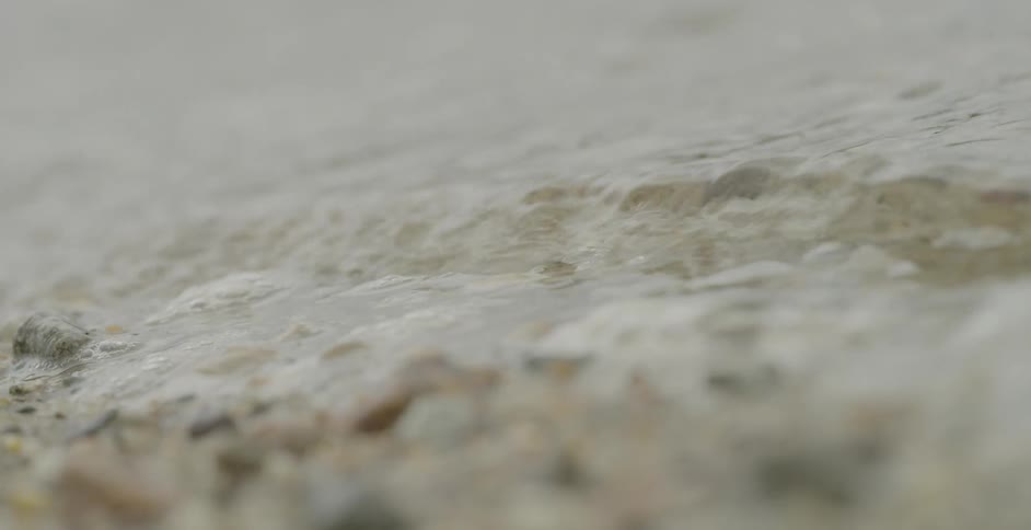 The ocean ebbs and flows on a rocky and sandy beach
