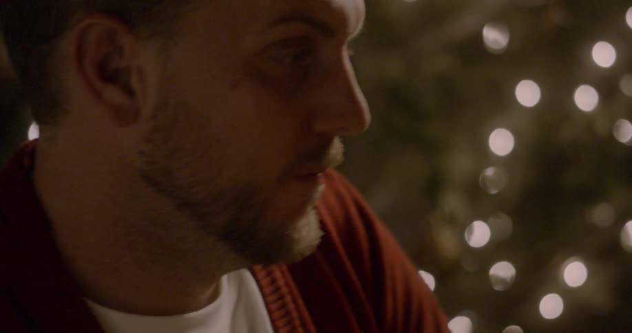 Man sits near a christmas tree