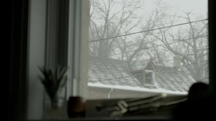 Window with a view of snow falling
