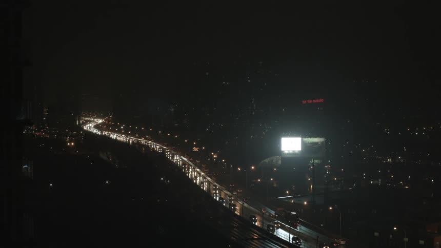 Vehicles travel on a city street at night