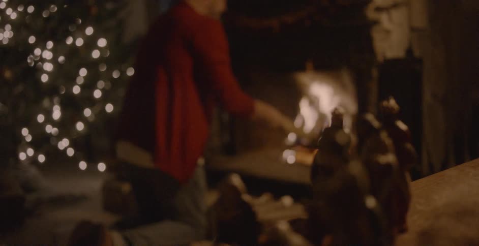 A man stokes a fire in a fireplace