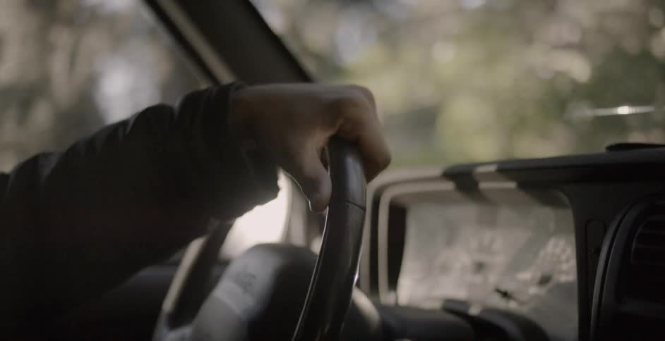 Persons hands on a steering wheel